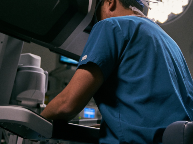 Surgeon seated, using davinci 5 surgical system